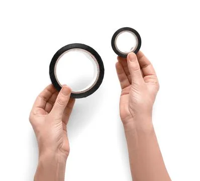 Hands holding two rolls of black electrical tape, one large and one small, fo Stock Photos