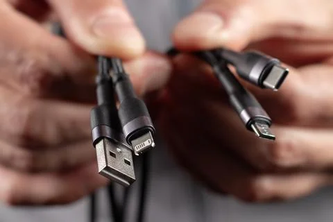 Hands holding universal adapter cable from USB connector to micro USB, mini-U 스톡 사진