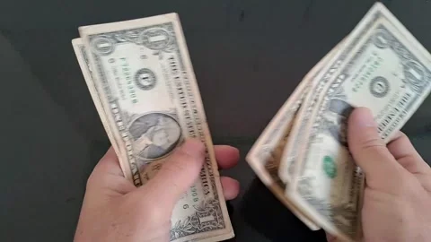 Hands holding US dollar bills in motion. Close-up of cash exchange and financial Stock Footage 340480964