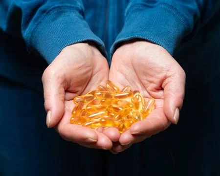 Hands holding Vitamin E Stock Photos