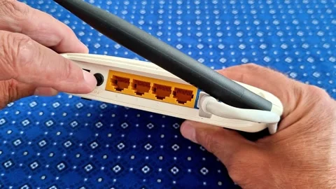 Hands Holding White Wi Fi Router with Antenna and Ethernet Ports Stock Footage 341840597
