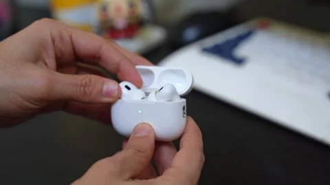 Hands Holding Wireless Earbuds Charging Case on Desk Stock Footage 312427780