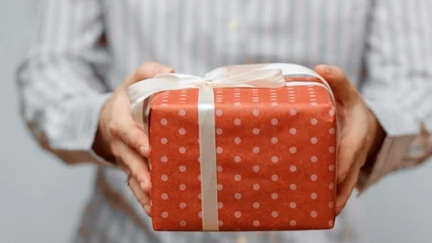 Hands holding wrapped present, gift box with ribbon and bow. Holidays packaging. Stock Footage 117191120