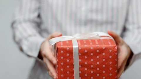 Hands holding wrapped present, gift box with ribbon and bow. Holidays packaging. Stock Footage 117191332