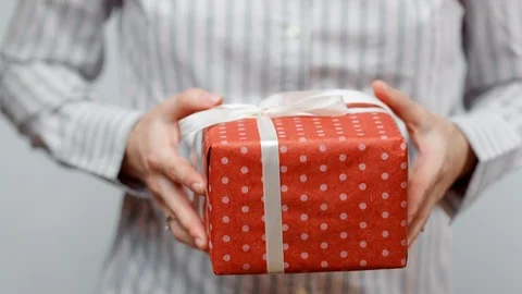 Hands holding wrapped present, gift box with ribbon and bow. Holidays packaging. Stock Footage 117191553