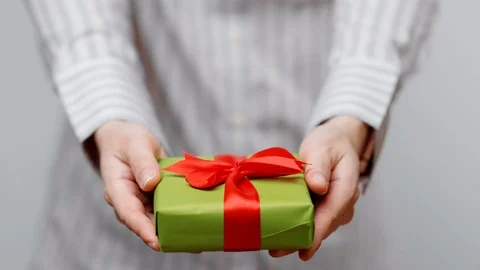 Hands holding wrapped present, gift box with ribbon and bow. Holidays packaging. Stock Footage 117191811