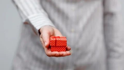 Hands holding wrapped present, gift box with ribbon and bow. Holidays packaging. Stock Footage 117192000