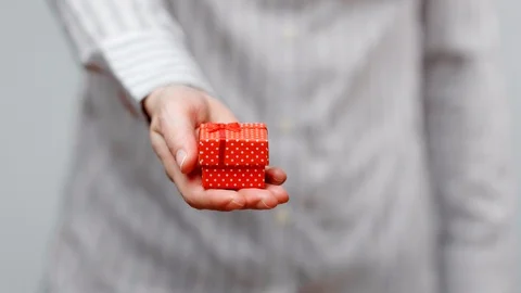 Hands holding wrapped present, gift box with ribbon and bow. Holidays packaging. Stock Footage 117192045