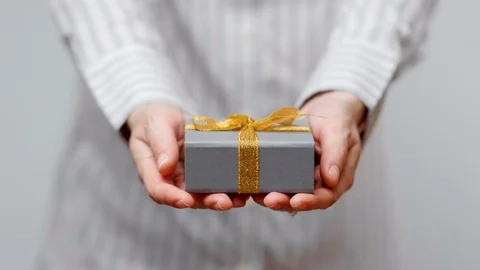 Hands holding wrapped present, gift box with ribbon and bow. Holidays packaging. Stock Footage 117192083