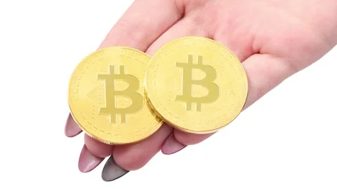Hands holds and shows two golden cryptocurrency bitcoin on white background Stock Footage 249951022