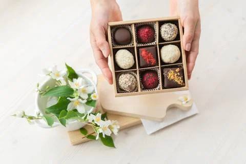 Hands holds a box of chocolates. assorted chocolates confectionery in their gift Stock Photos