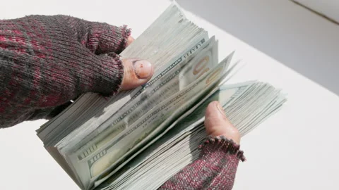 Hands of homeless person checking thick wad of one hundred dollar bills Stock Footage 330287701