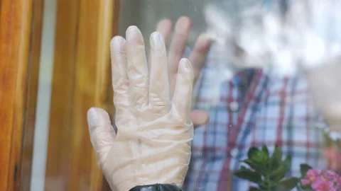 Hands of hope. A woman visits her elderly father, who is in isolation with his Stock Footage