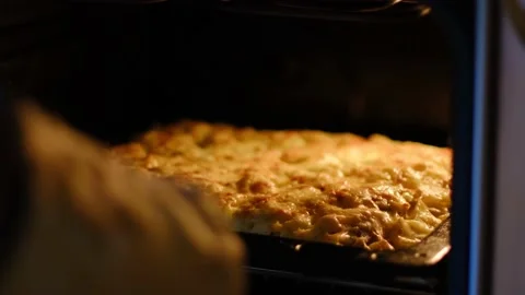 The hands of the hostess in gloves take out the casserole from the oven Stock Footage 151546253