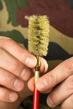 Hands of hunter attach a nylon brush to the cleaning rod Stock Photos