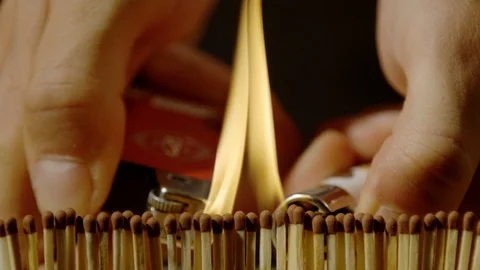 Hands igniting a row of matchsticks with lighters, Ultra Slow Motion Stock Footage 86576071