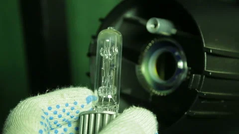 In the hands of the illuminator in gloves is a halogen lamp for a profile Stock Footage 104155564