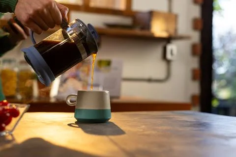Hands of indian man making coffee and using smartphone in kitchen at home, copy 写真素材