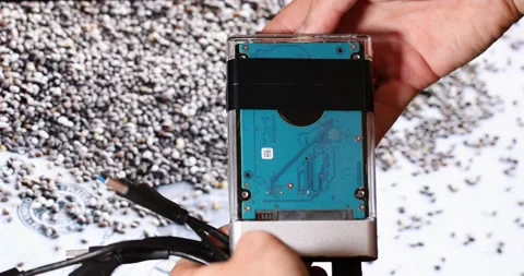 Hands insert a hard drive holding the wires against the background of chia seeds Stock Footage 156014402