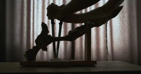 Hands insert long, thin jamon knives into wooden ham stand. Dark silhouette of 스톡 동영상 199393046