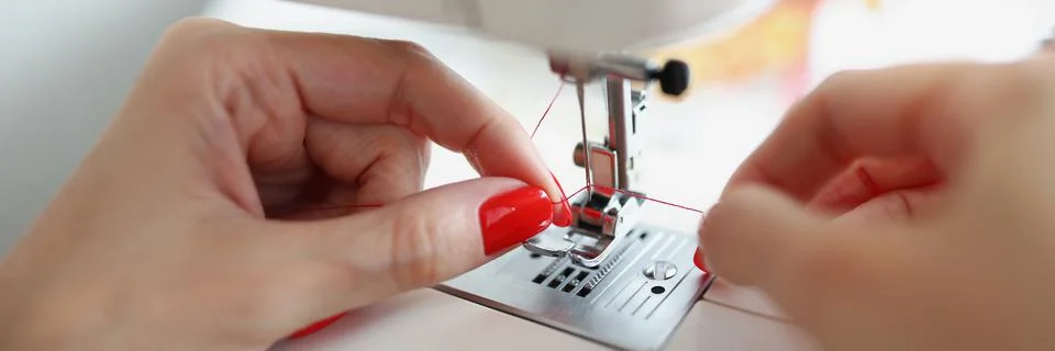 Hands insert thread into the machine needle Stock Photos