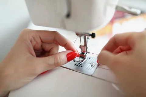 Hands insert thread into the machine needle Stock Photos