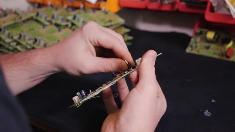 Hands inserting electronic component into printed circuit board - close up Video stock 139515335