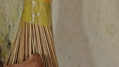 Hands inserting extra palm leaf ribs into a traditional broom to tighten an.. Stock Footage 324822929