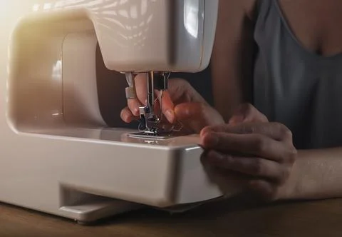 Hands inserting thread through needle hole in sewing machine, details Foto stock