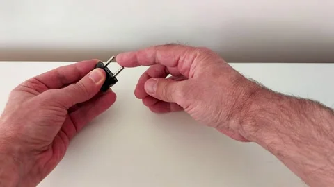 Hands Inspecting Electrical Plug on Clean White Surface Vídeos de archivo 319981135
