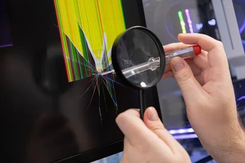 Hands inspecting a severely cracked computer monitor screen with a magnifyi.. Foto stock