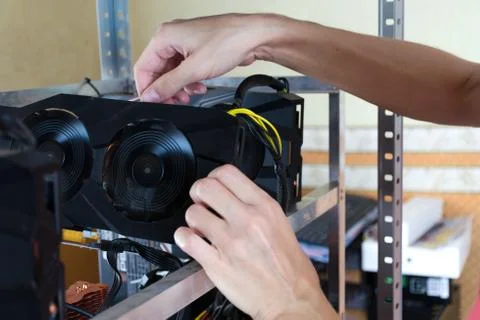 Hands install graphics card into computer for Bitcoin mining and other. Stock Photos