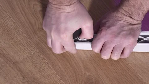 Hands install a wheel into the plastic leg of an office chair during assembly. Stock Footage 327910051