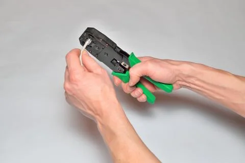 Hands of the installer of computer networks ticks crimped connector Stock Photos
