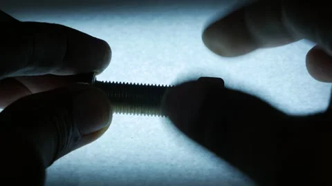 Hands Installing Metal Hex Nut onto Threaded Bolt Stock Footage 340069105
