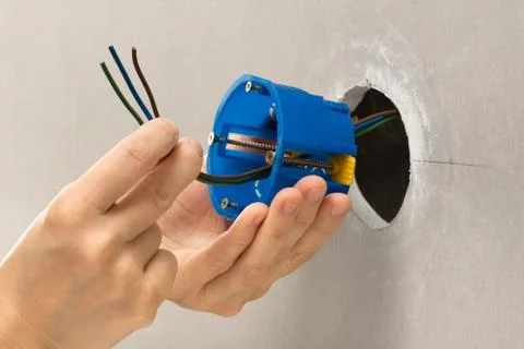Hands installing plastic outlet box Stock Photos