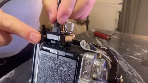 Hands installing USB-C cable on camera cage close-up, connecting power or data Stock Footage 333649615