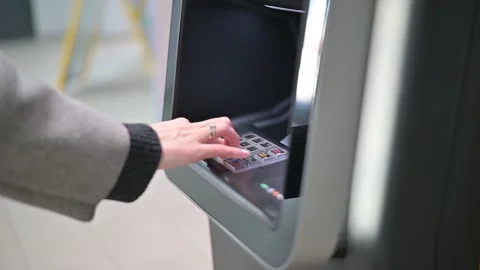 Hands interact with an ATM machine, entering information and navigating the 库存影片 337555784