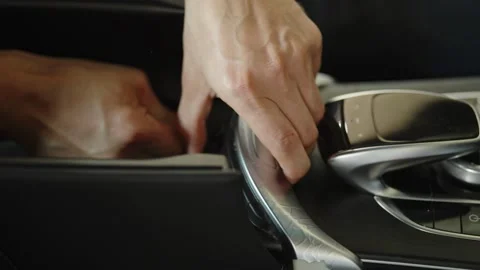 Hands interacting with the modern center console of luxury car Stock Footage 337567928
