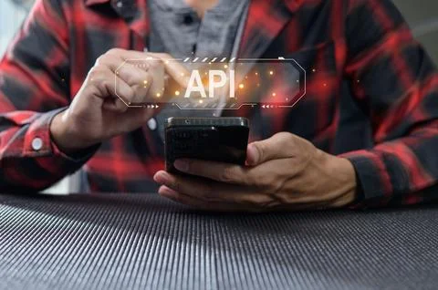 Hands Interacting with Smartphone Displaying API Programming Concept Foto stock