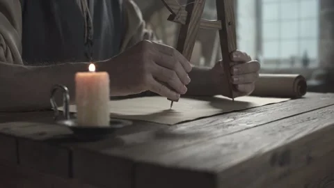 Hands of an inventor using a wooden divider to draw an arc on a blueprint Stock Footage 337930204