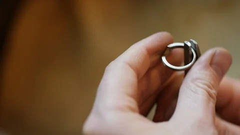Hands of a jeweler testing the strength of a ring with some pliers Stock Footage 102031857