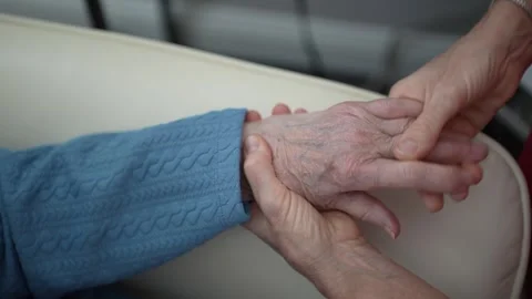 Hands Joining in Support During a Caring Moment in a Warm Setting Stock Footage 306073476