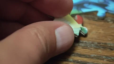 Hands joining two jigsaw puzzle pieces Vidéo 310300209