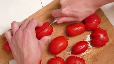 Hands  kitchen knife cutting fresh tomato on wooden cutting board. Top view. Stock Footage 142216519