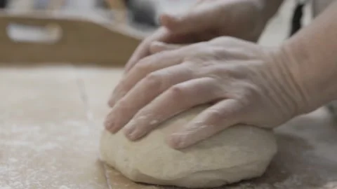 Hands knead a bread dough on a vintage baking table Stock Footage 233386622