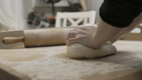 Hands knead a bread dough on a vintage baking table Stock Footage 233386725