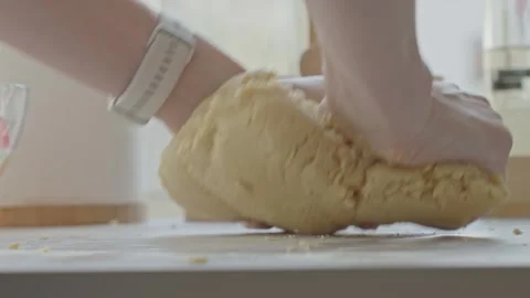 Hands knead dough on kitchen surface during baking preparation Stock Footage 333536373