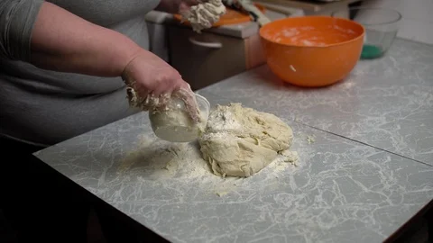 Hands knead the dough on the kitchen table. Stock Footage 120899948
