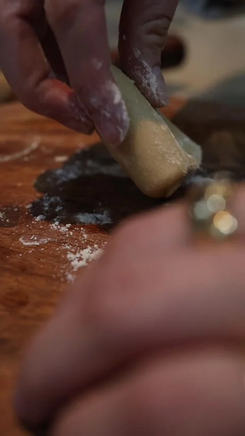 Hands kneading and folding dough for homemade chapatis on wooden surface Video stock 345072892